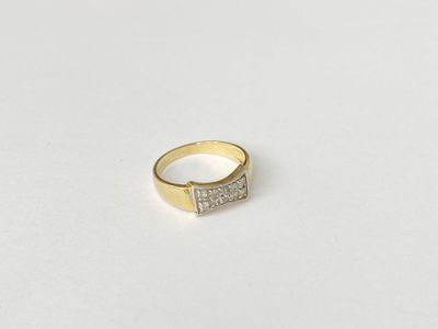 a close up of a gold and diamond ring on a white surface