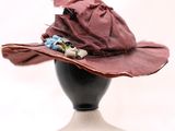 chapeau violet orné de fleurs, posé sur la tête d'un mannequin