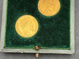 une image représentant deux pièces d'or dans un écrin en velours vert