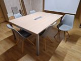 des tables et des chaises dans une pièce où se trouve un tableau blanc accroché au mur