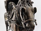 statue of a horse pulling a buggy with a carriage behind it