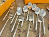 a lot of silver spoons and forks on a table