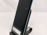 a broken cell phone sitting on a stand on a table