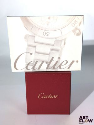 La montre Cartier est posée sur un coffret rouge
