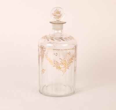 a clear glass bottle with a gold leaf design on the top