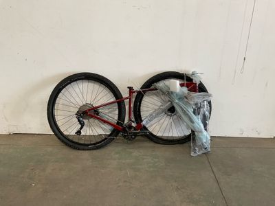 un vélo posé contre un mur, avec un sac dessus