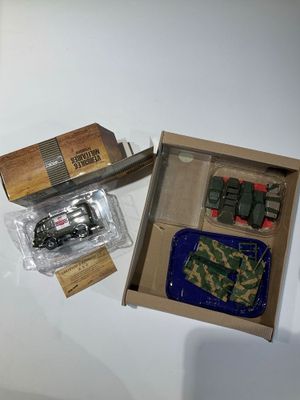 une boîte contenant un véhicule militaire miniature et d'autres objets