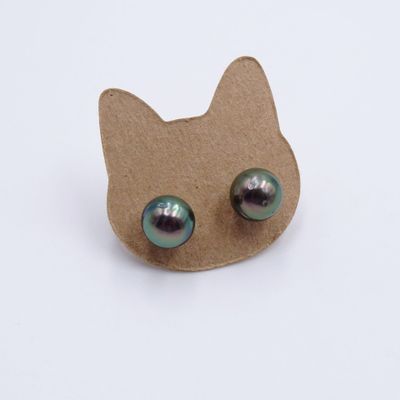 une boucle d'oreille en forme de chat avec des yeux verts