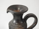 a black vase that is sitting on a table