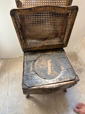a person standing next to a chair that has a hole in it