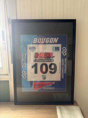 a framed picture of a race bicyclist on a table