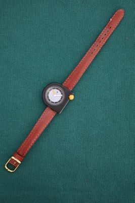 a close up of a wrist watch on a green surface