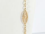 a close up of a gold necklace with a chain on a mannequin