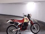a red and white motorcycle parked in a parking garage