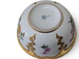 a white bowl with a gold rim and flowers on it