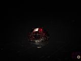 a close up of a red diamond on a black surface