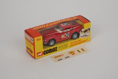 une petite voiture rouge dans une boîte sur une surface blanche