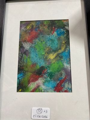 painting of a colorful abstract painting in a black frame on a table