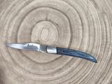 a knife sitting on top of a piece of wood