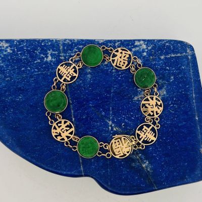 a close up of a green bracelet on a blue surface