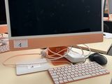 a computer monitor sitting on a desk with a keyboard and mouse