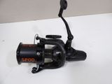 a close up of a spinning fishing reel on a white surface
