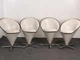three white chairs with black trims sit in front of a white wall