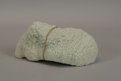 a white rock with a rope on it on a gray surface