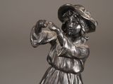 a statue of a woman with a hat holding a bird