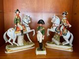 trois figurines représentant des hommes à cheval, posées sur une étagère