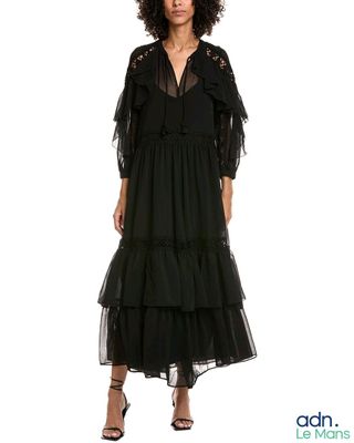 une femme vêtue d'une robe noire et de talons hauts, debout devant un fond blanc