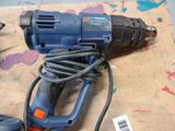 a drill and a cord on a table with paint
