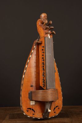 an old wooden instrument with a knife on top of it on a wooden table