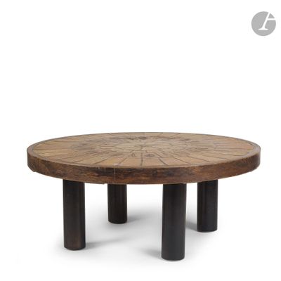 a round wooden table with four black legs and a circular wooden table top