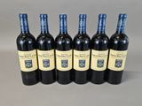 six bottles of red wine are lined up in a row