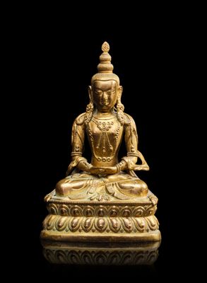 une statue en or représentant un Bouddha assis sur un socle noir