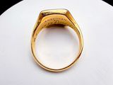 an image of a gold signet ring on a white surface