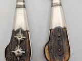 pair of antique silverware spoons with wooden handles on a white surface