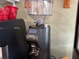 un moulin à café posé sur un plan de travail, à côté d'un micro-ondes