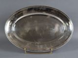 a silver plate on a stand on a grey background