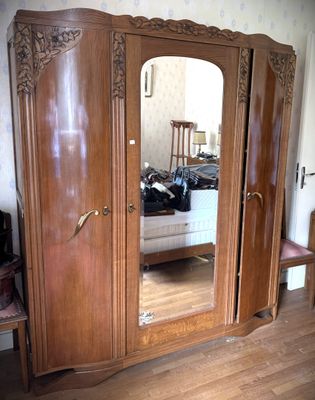 une grande armoire en bois munie d'un miroir