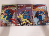 trois bandes dessinées de Superman posées sur une surface blanche