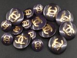 quelques boutons violets avec des lettres dorées se trouvent sur une surface noire