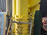 beaucoup d'articles jaunes sur une palette à côté d'un bâtiment