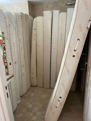 many mattresses stacked up in the corner of a room