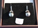pair of pearl earrings in a box with a price tag on it