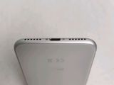 the back of a silver cell phone sitting on top of a white surface