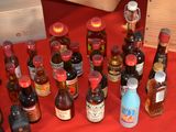 many bottles of alcohol on a red table cloth