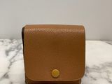 a small tan leather wallet on a marble surface