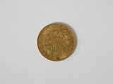 a close up of a gold coin on a white surface